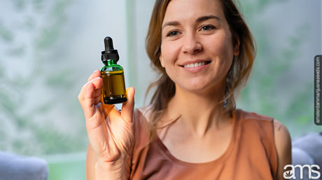 a woman with a serene gaze holding a bottle of CBD in her hand